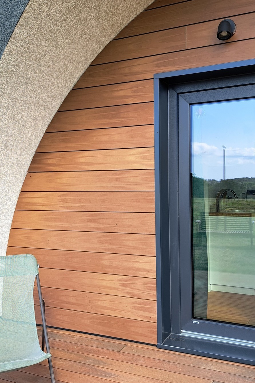 Façade en bois composite Silvadec avec bardage horizontal installé sur une maison contemporaine, mettant en valeur le contraste entre le bois composite et les encadrements de fenêtre en aluminium anthracite