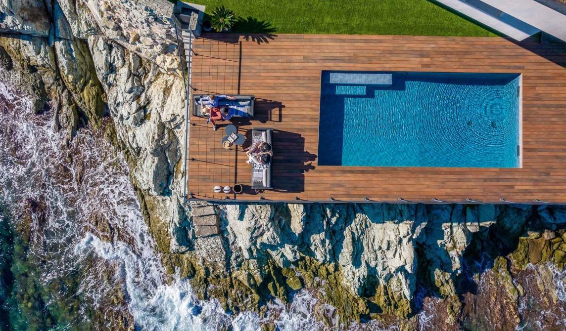 Terrasse en bois composite avec piscine de la Villa Cyrnos en Corse - Aménagement extérieur contemporain avec vue mer et montagne