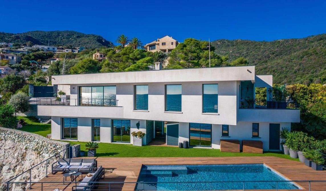 Terrasse en bois composite avec piscine de la Villa Cyrnos en Corse - Aménagement extérieur contemporain avec vue mer et montagne