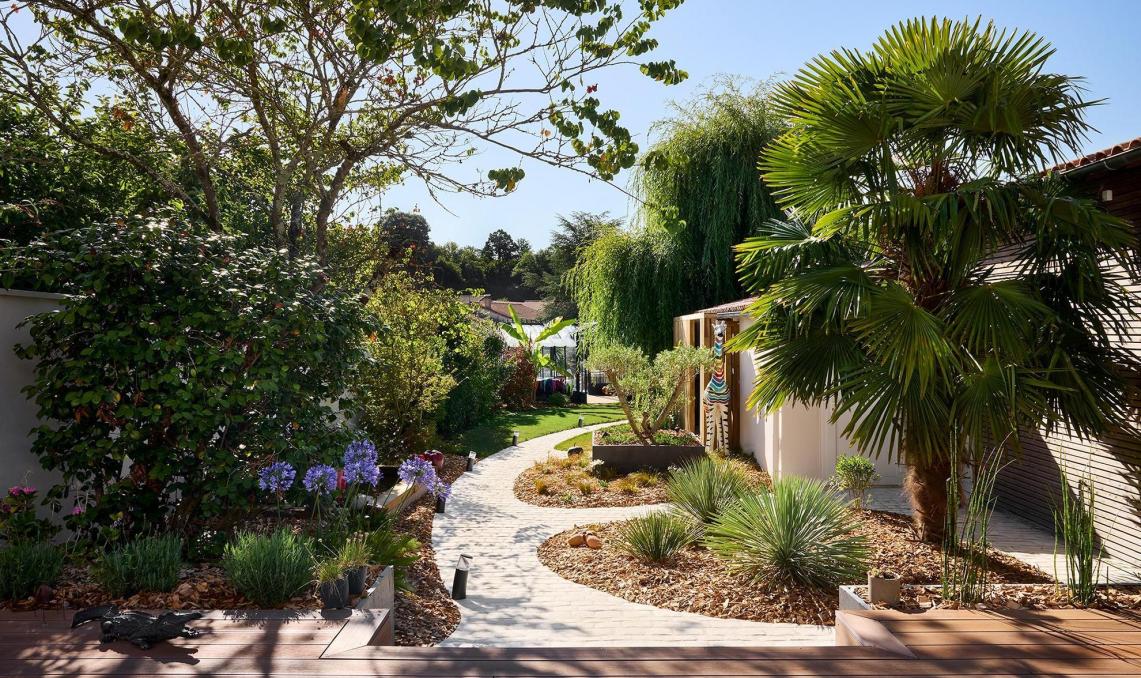 Pool-house contemporain à bardage bois cintré et terrasse composite Nuances Ipé, réalisation O'xygen Paysagist