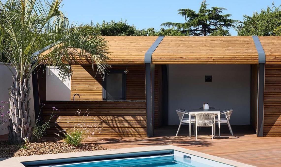 Terrasse composite Nuances Ipé en plage de piscine, vue latérale avec pool-house et palmiers, résidence privée