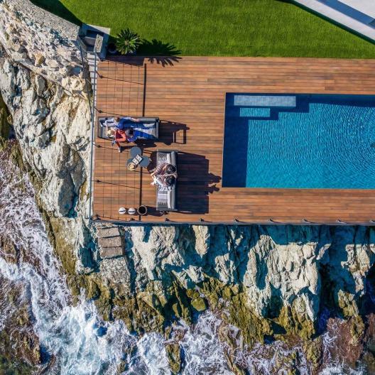 Terrasse en bois composite avec piscine de la Villa Cyrnos en Corse - Aménagement extérieur contemporain avec vue mer et montagne
